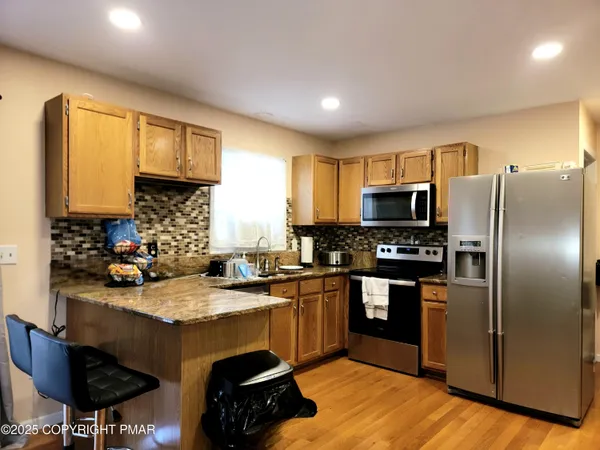 a kitchen with granite countertop a sink stove and refrigerator
