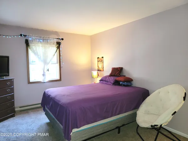 a bedroom with a bed a dresser and chair