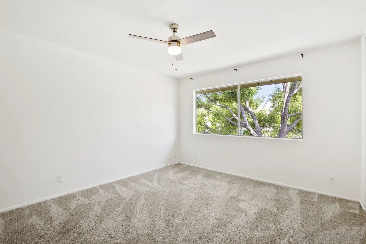 143 Cerco Rosado San Marcos, CA 92069 - Photo 17 of 28 an empty room with windows and ceiling fan