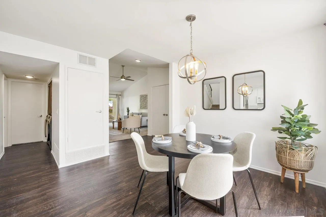 143 Cerco Rosado San Marcos, CA 92069 - Photo 7 of 28 a dining room with wooden floor a chandelier a glass table and chairs
