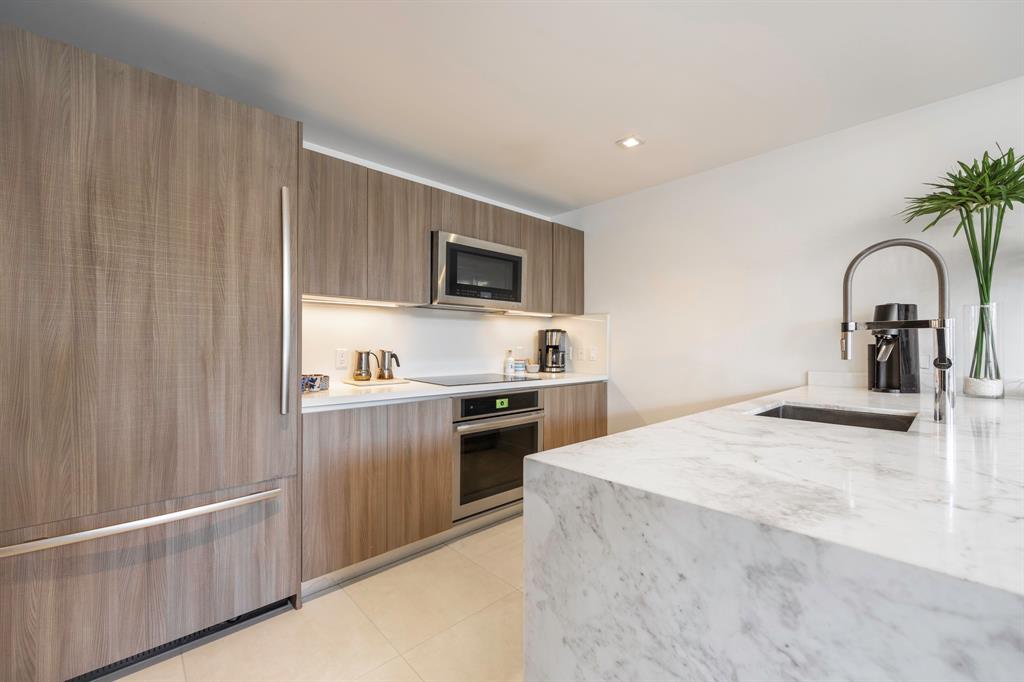 401 North Birch Road, Unit TH7 Fort Lauderdale, FL 33304 - Photo 12 of 33 a kitchen with stainless steel appliances granite countertop a sink and stove top oven