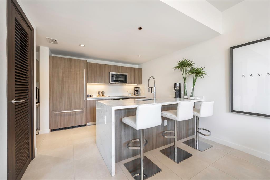 401 North Birch Road, Unit TH7 Fort Lauderdale, FL 33304 - Photo 13 of 33 a living room with furniture a potted plant and kitchen view