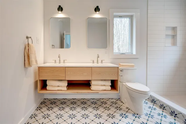 a bathroom with a sink a toilet and shower