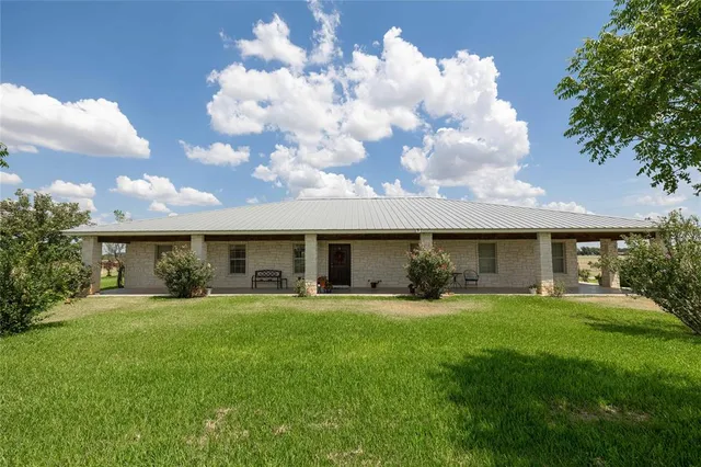 a view of a house with a yard and sitting area