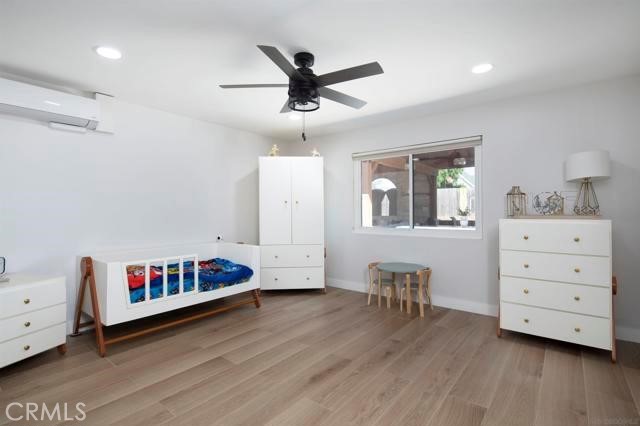 14085 Proctor Valley Road Jamul, CA 91935 - Photo 27 of 70 a living room with furniture and a baby crib with wooden floor