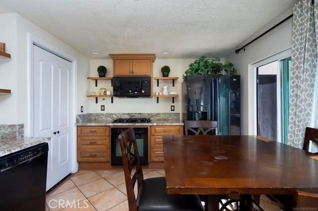14085 Proctor Valley Road Jamul, CA 91935 - Photo 63 of 70 a kitchen with kitchen island granite countertop a stove top oven a sink a dining table and chairs