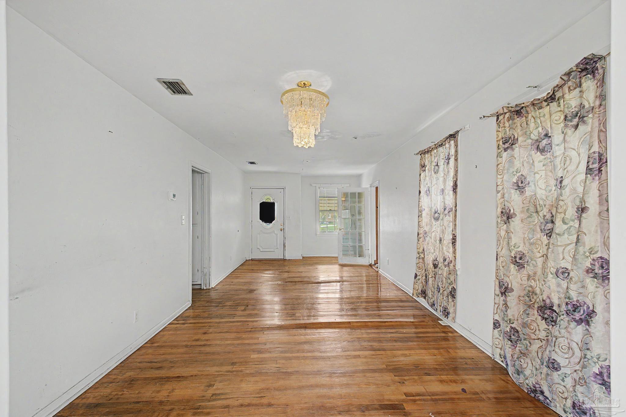 333 Gibbs Road Pensacola, FL 32507 - Photo 6 of 34 a view of an empty room with wooden floor