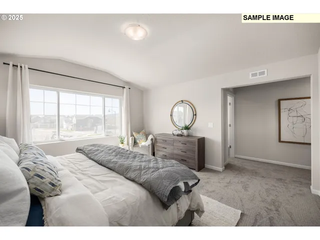 a bedroom with a bed and large windows