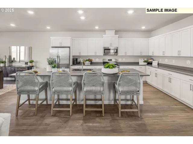 a kitchen with stainless steel appliances kitchen island granite countertop a dining table chairs and white cabinets