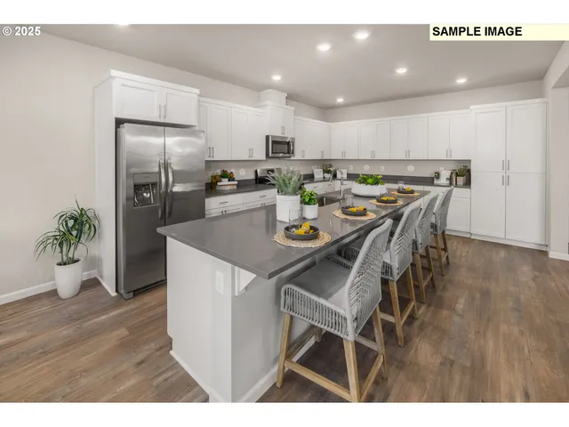 a kitchen with a dining table chairs refrigerator and microwave