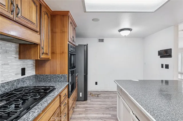 a kitchen with granite countertop a sink stove and refrigerator