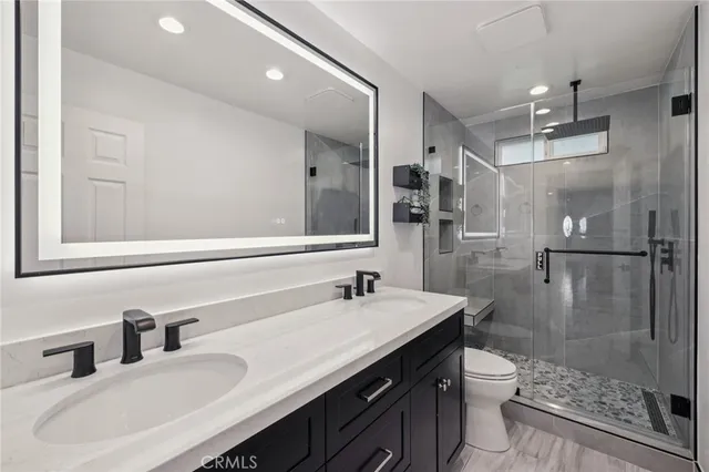 a bathroom with a sink toilet a mirror and shower