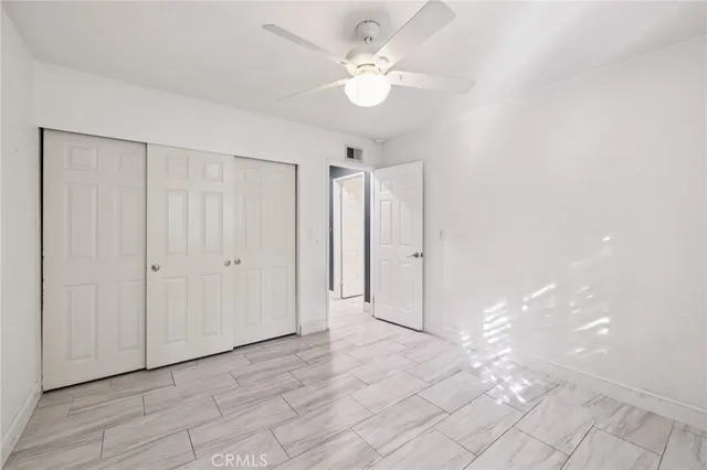 wooden floor in an empty room with a ceiling fan