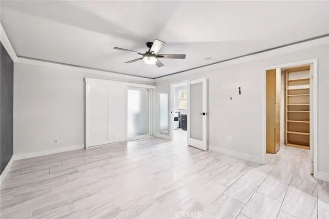a view of empty room with wooden floor and ceiling fan