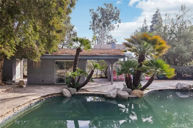 a house view with a swimming pool and porch