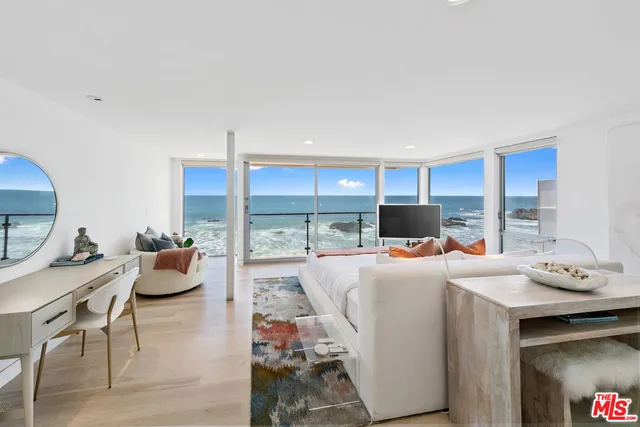 a spacious bedroom with a bed a couch and a potted plant