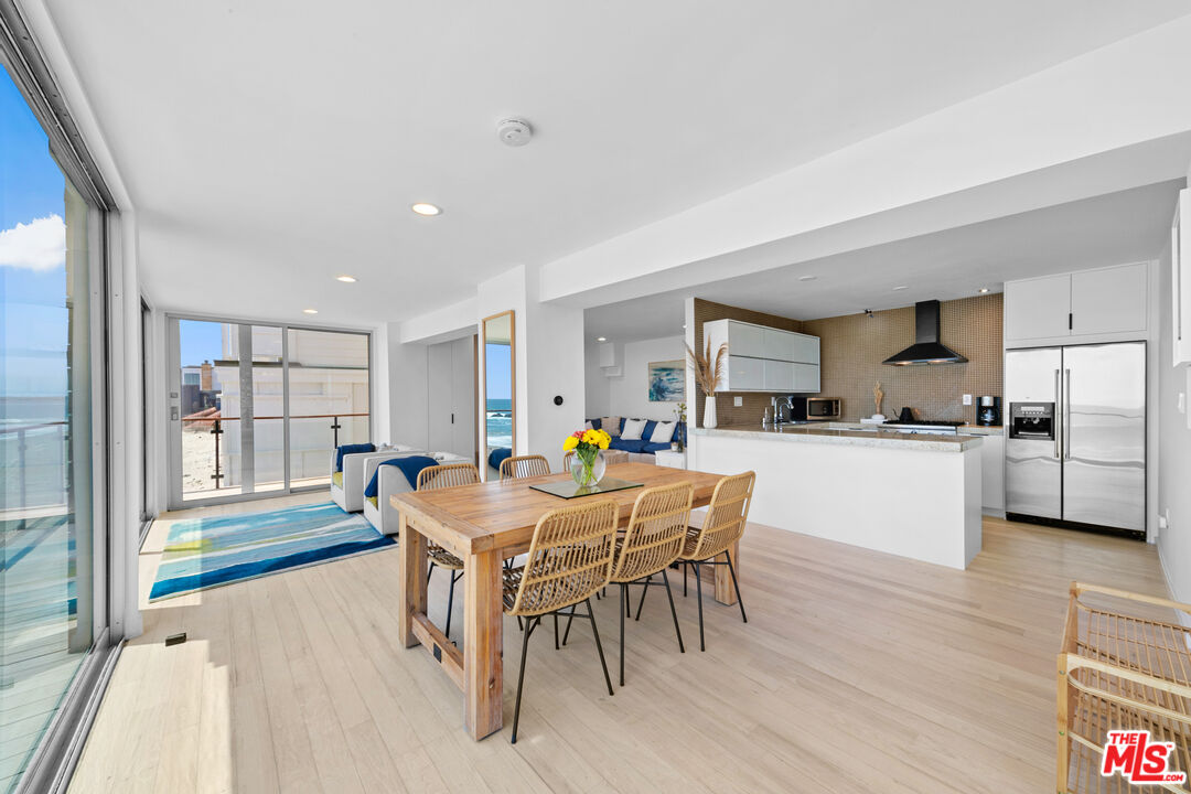 24928 Malibu Road Malibu, CA 90265 - Photo 35 of 50 a dining room with furniture and a floor to ceiling window