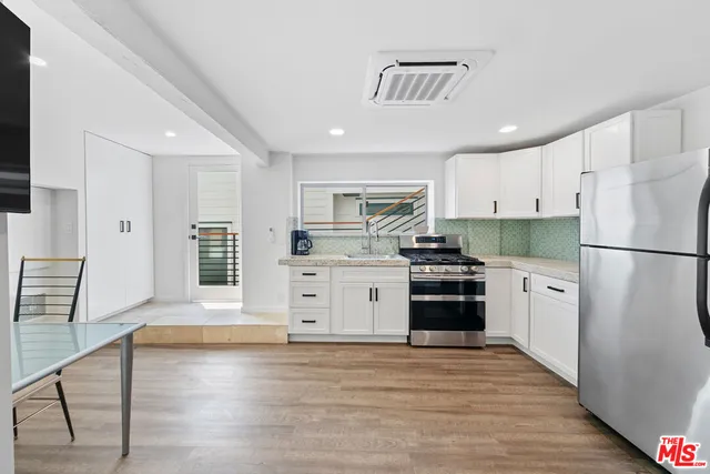 a kitchen with stainless steel appliances granite countertop a sink a stove and a refrigerator