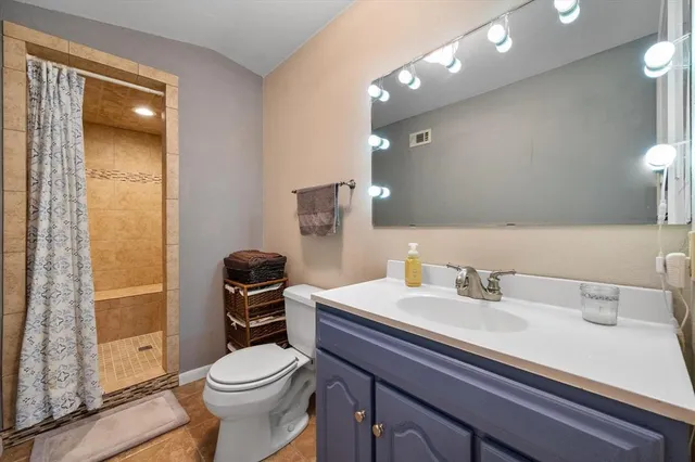 a bathroom with a toilet a sink and a mirror