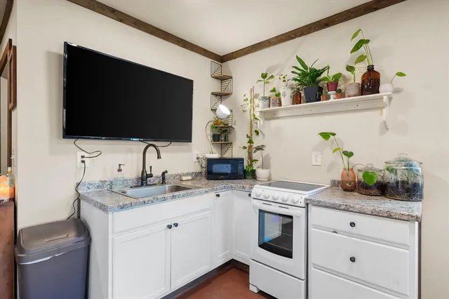 a living room with furniture flat screen tv and windows