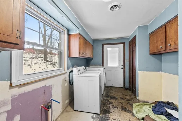 a living room with furniture and kitchen view with wooden floor