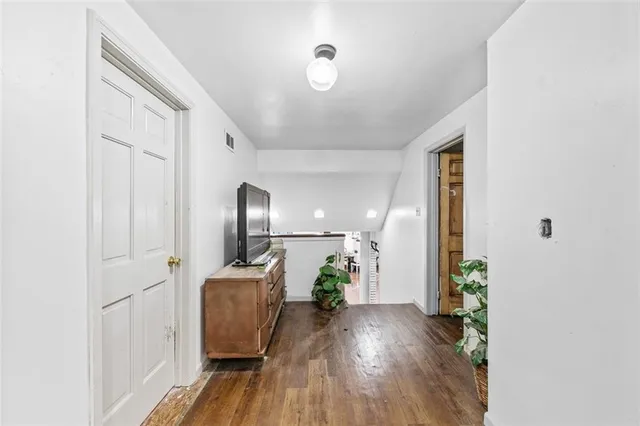 a view of empty room with wooden floor