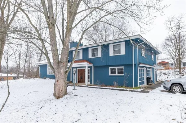 a front view of a house with a yard covered in snow