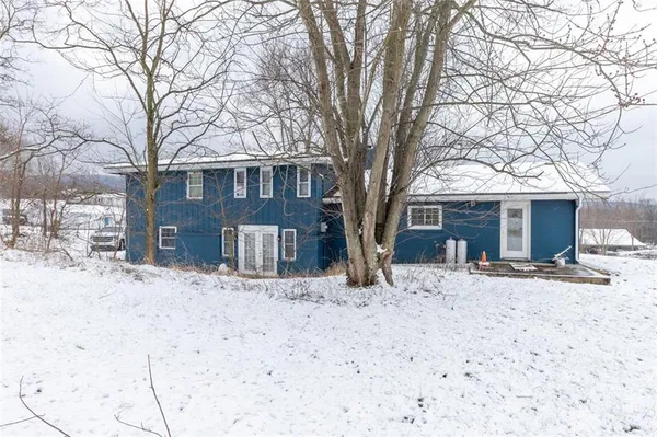 a front view of a house with a yard covered in snow