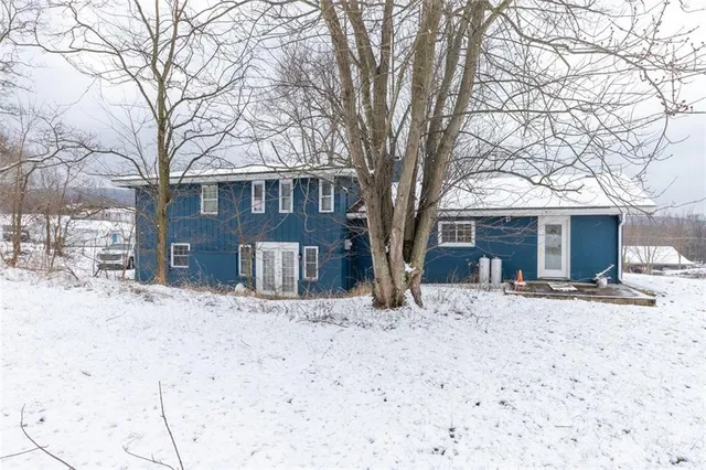 a front view of a house with a yard covered in snow
