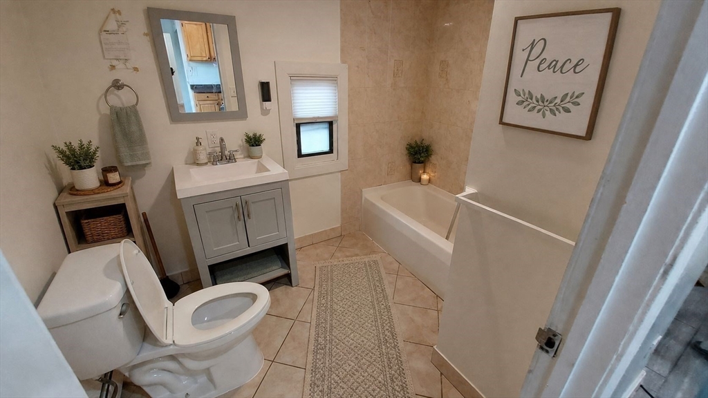 124 Marcella Street, Unit 1 Boston, MA 02119 - Photo 11 of 13 a bathroom with a bathtub sink and toilet