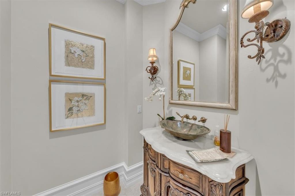 2116 Canna Way Naples, FL 34105 - Photo 17 of 50 a bathroom with a table and a mirror