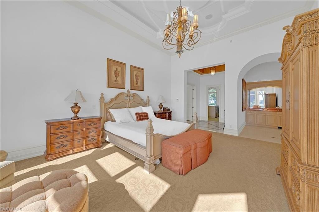 2116 Canna Way Naples, FL 34105 - Photo 21 of 50 a bed room with a bed and a chandelier