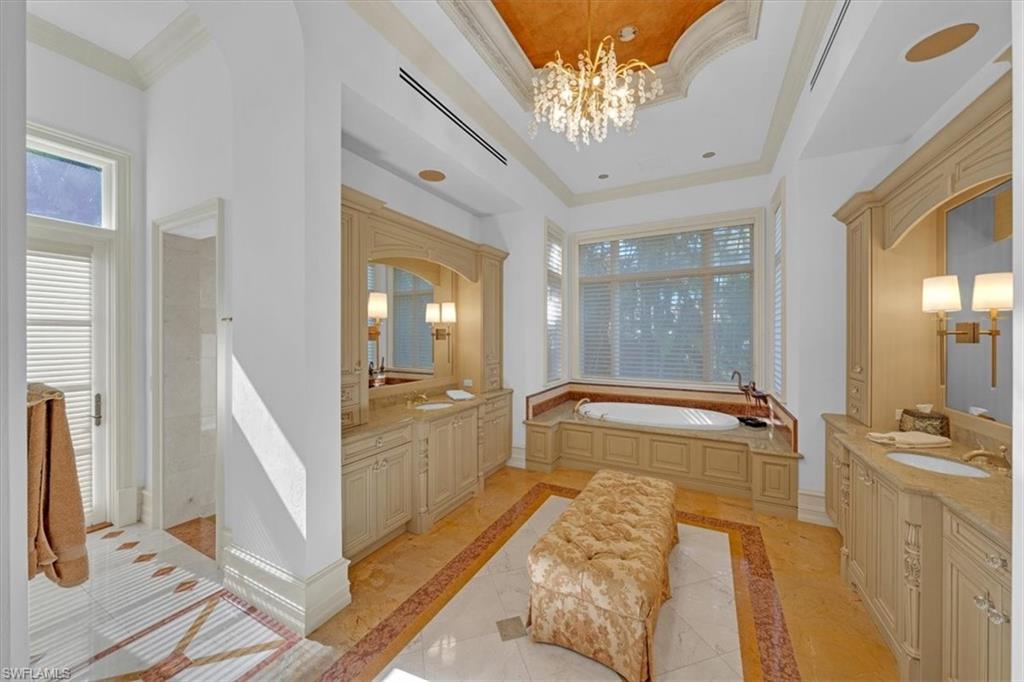2116 Canna Way Naples, FL 34105 - Photo 23 of 50 a spacious bathroom with a double vanity sink a mirror and a shower