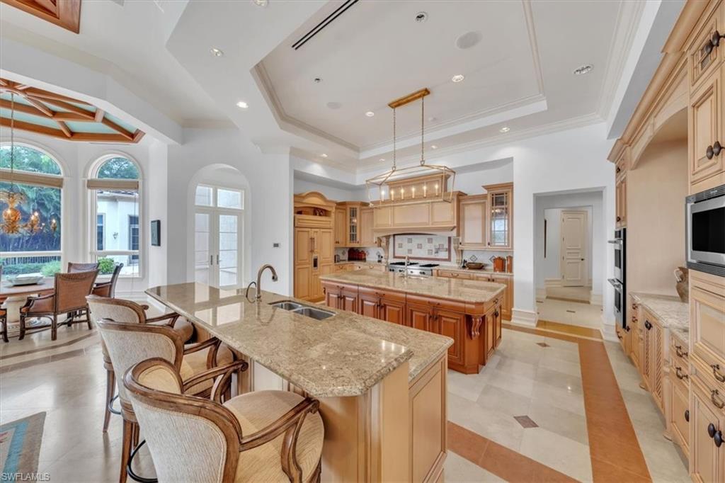 2116 Canna Way Naples, FL 34105 - Photo 32 of 50 a large kitchen with a table and chairs