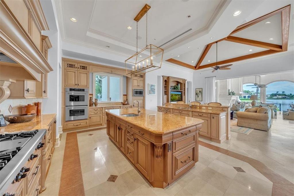 2116 Canna Way Naples, FL 34105 - Photo 33 of 50 a large white kitchen with a large island in the center