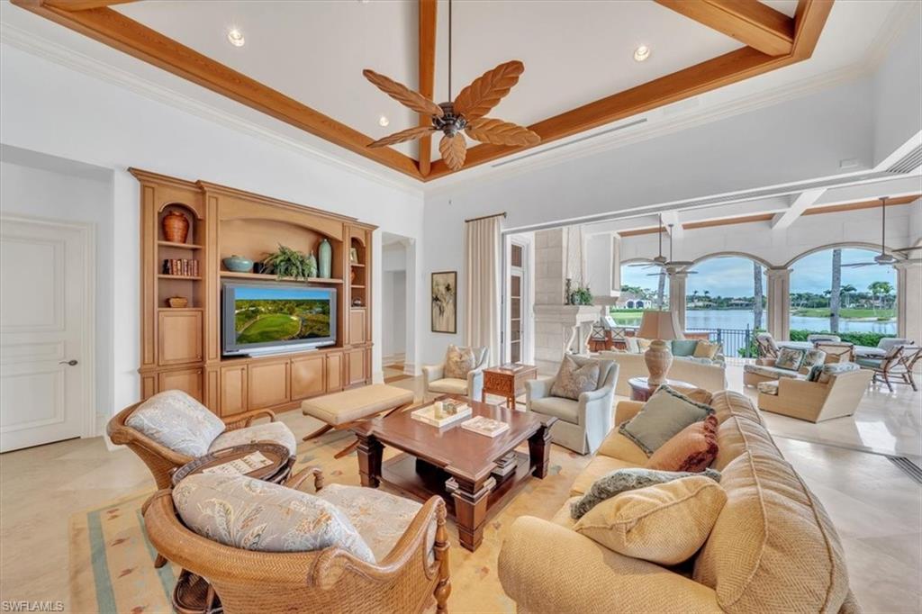 2116 Canna Way Naples, FL 34105 - Photo 35 of 50 a living room with furniture a ceiling fan and a large window