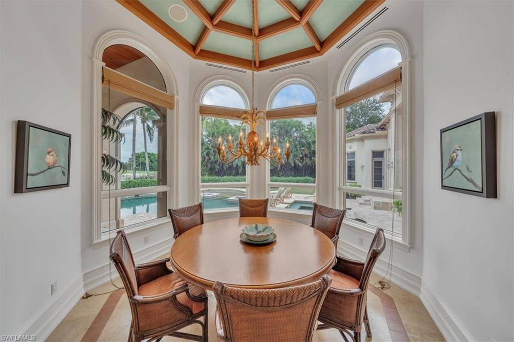 2116 Canna Way Naples, FL 34105 - Photo 37 of 50 a dining room with furniture a chandelier and wooden floor