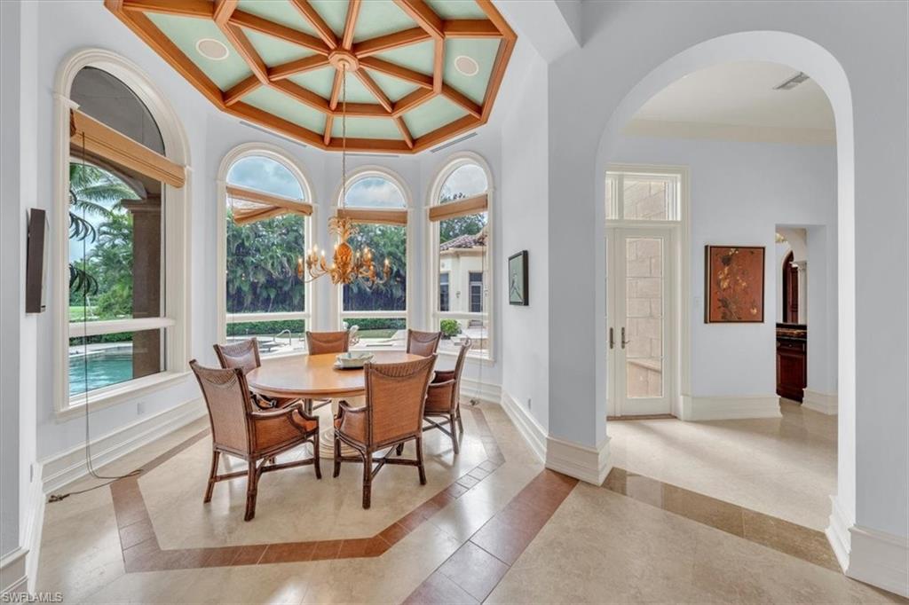 2116 Canna Way Naples, FL 34105 - Photo 38 of 50 a dining room with furniture a chandelier and a rug