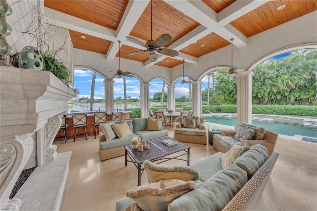 2116 Canna Way Naples, FL 34105 - Photo 40 of 50 a living room with patio furniture and a large window