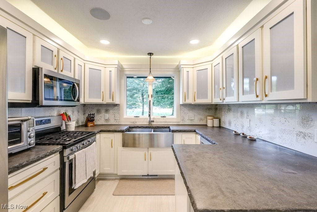 1598 Graham Road Silver Lake, OH 44224 - Photo 24 of 46 Kitchen with pendant lighting, white cabinetry, tasteful backsplash, stainless steel appliances, and sink