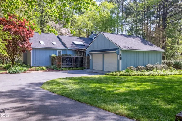 a front view of a house with a yard and trees