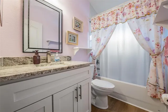 a bathroom with a granite countertop sink toilet a mirror and shower