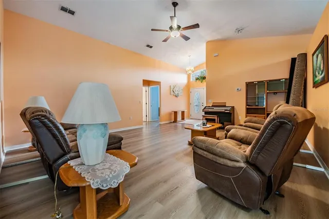 a living room with furniture or chandelier and a wooden floor