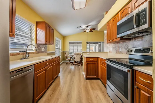 a kitchen with stainless steel appliances granite countertop a stove a sink dishwasher and a microwave oven with cabinets
