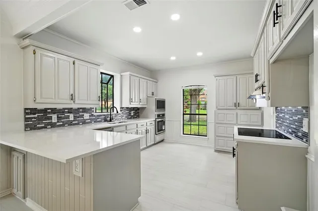 a kitchen with stainless steel appliances granite countertop a sink and a stove top oven