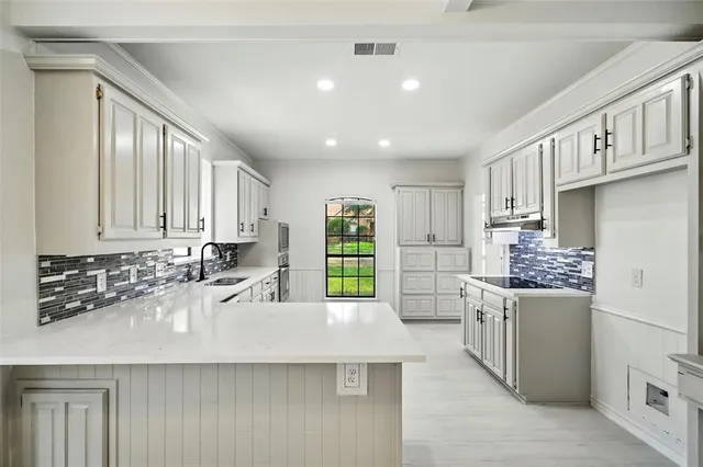 a kitchen with a sink stove and cabinets