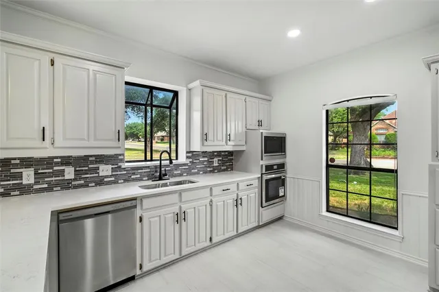 a kitchen with stainless steel appliances a stove sink and microwave