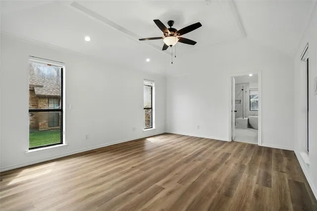 an empty room with closet and a ceiling fan