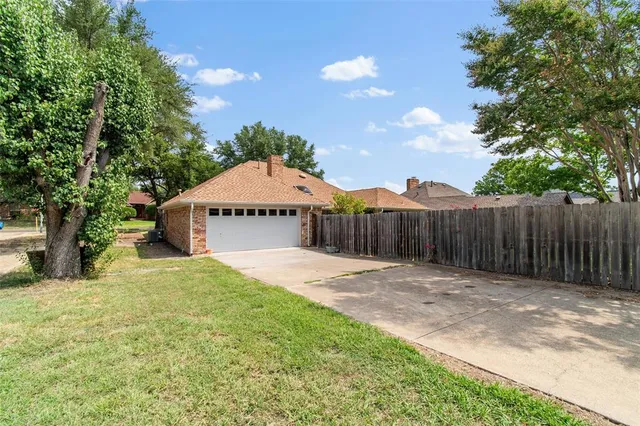 an aerial view of a house with garden space and a patio