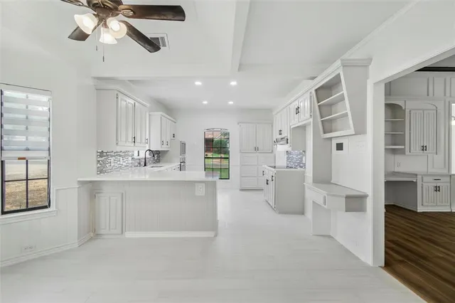 a open kitchen with granite countertop a sink cabinets stainless steel appliances and a large window